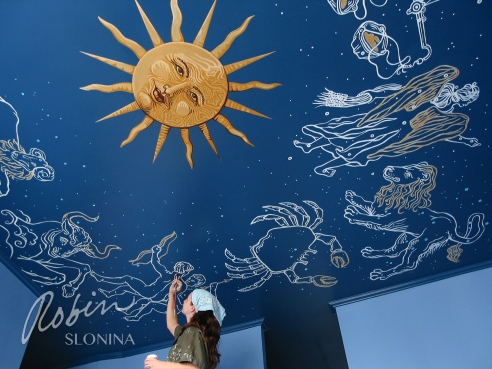 Robin Slonina working on one of her murals